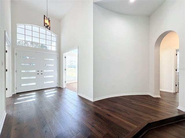 foyer entrance featuring dark hardwood / wood-style floors, a high ceiling, and a chandelier