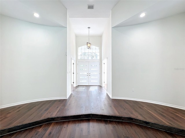 entrance foyer featuring wood-type flooring, a high ceiling, and french doors