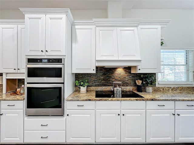 kitchen with backsplash, black electric cooktop, white cabinets, and double oven