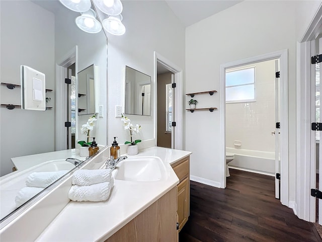 full bathroom with wood-type flooring, vaulted ceiling, toilet, vanity, and shower / bathtub combination