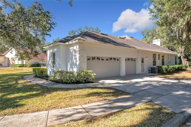 view of property exterior with central air condition unit, a yard, and a garage