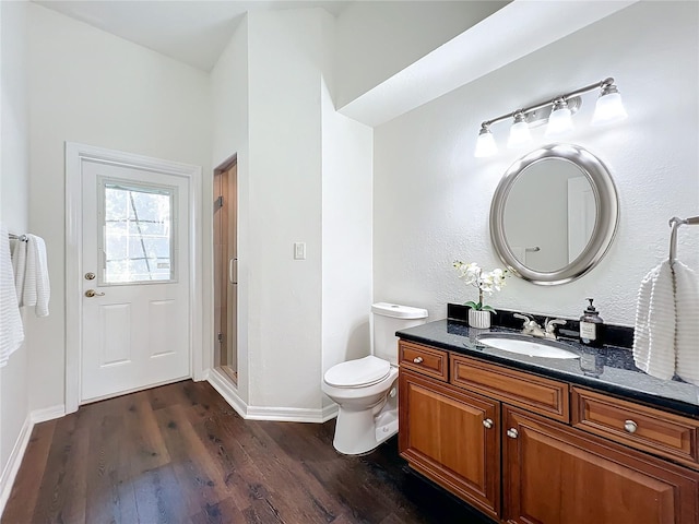 bathroom with vanity, toilet, wood-type flooring, and walk in shower