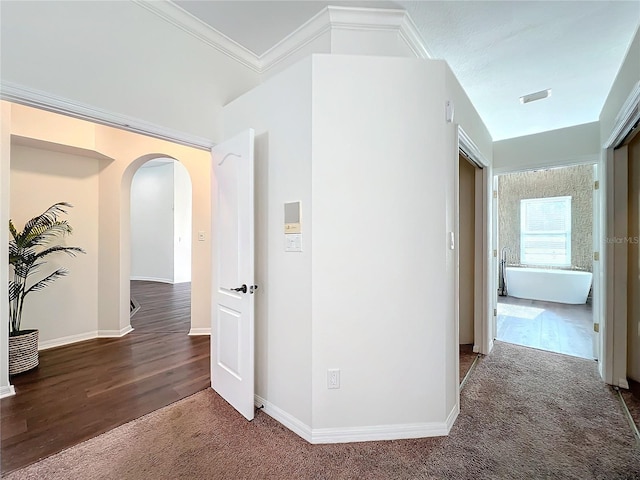 corridor with dark carpet and crown molding