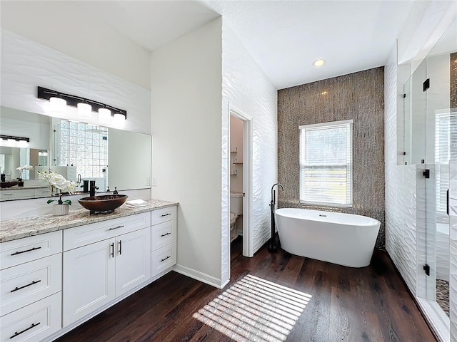 full bathroom featuring vanity, plus walk in shower, toilet, tile walls, and wood-type flooring