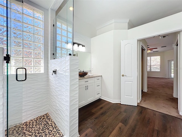 bathroom featuring ceiling fan, hardwood / wood-style floors, vanity, and walk in shower