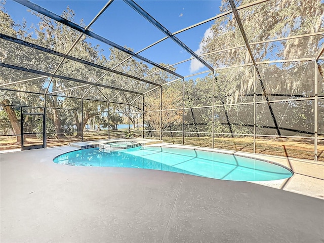 view of swimming pool with glass enclosure, an in ground hot tub, and a patio