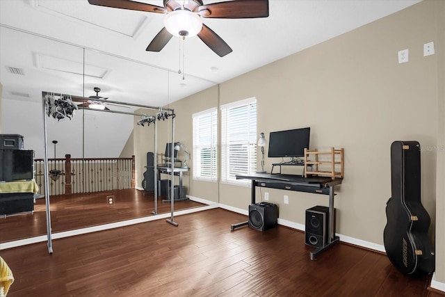 workout area with ceiling fan and dark wood-type flooring