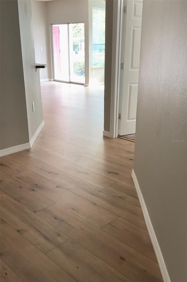 corridor with light hardwood / wood-style floors