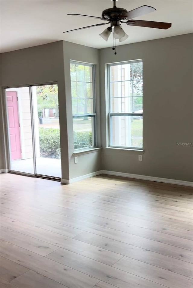 spare room with ceiling fan and light wood-type flooring