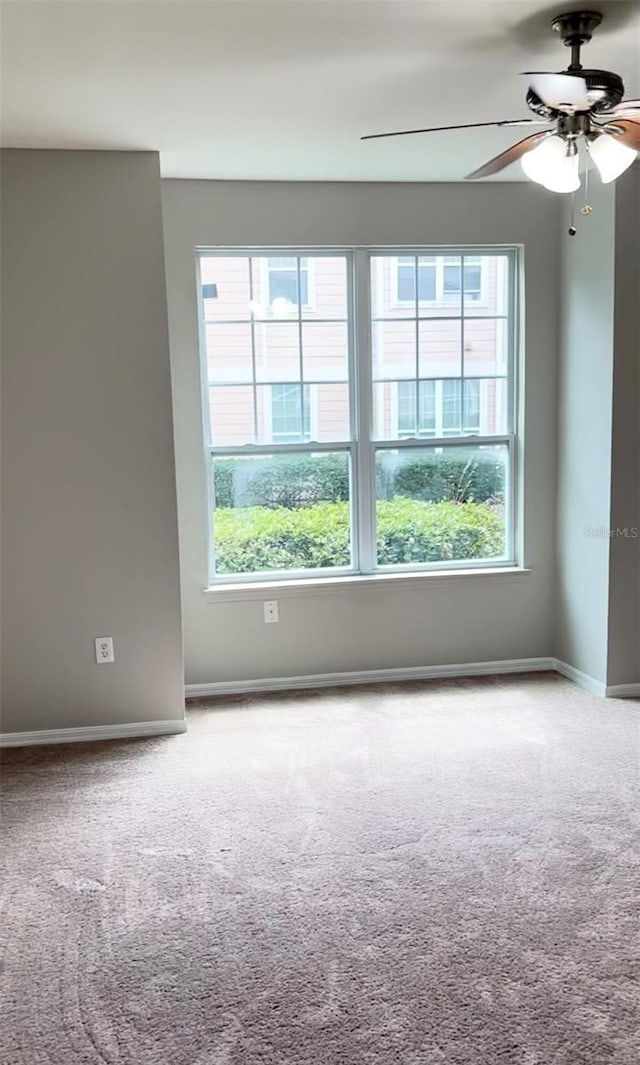 spare room with ceiling fan, carpet floors, and a wealth of natural light