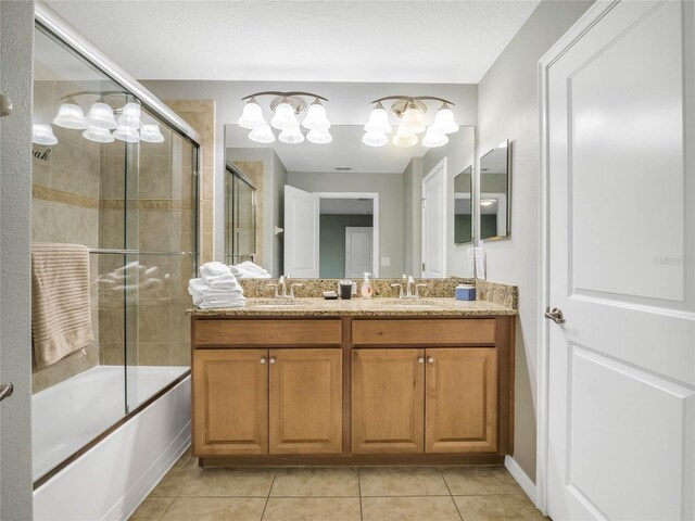 bathroom featuring vanity, tile patterned floors, and bath / shower combo with glass door