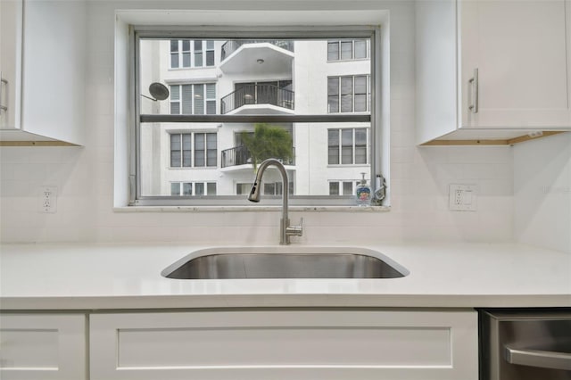 kitchen with decorative backsplash, a wealth of natural light, sink, and white cabinets