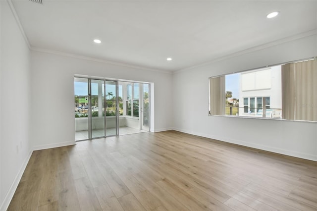 empty room with plenty of natural light, light wood-type flooring, and ornamental molding