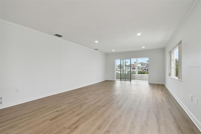 empty room featuring light hardwood / wood-style floors and crown molding