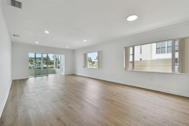 spare room featuring light hardwood / wood-style floors and ornamental molding