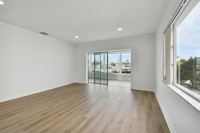 spare room with ornamental molding and light wood-type flooring