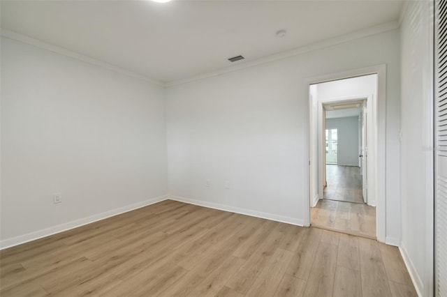 empty room with light hardwood / wood-style flooring and ornamental molding