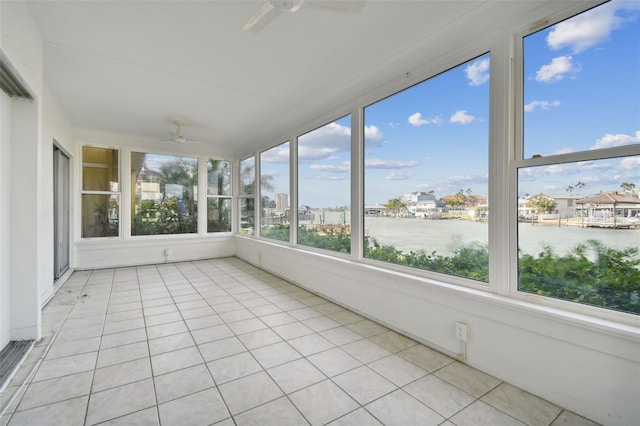 unfurnished sunroom featuring a water view and ceiling fan