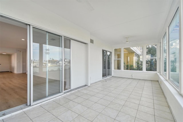 unfurnished sunroom with ceiling fan