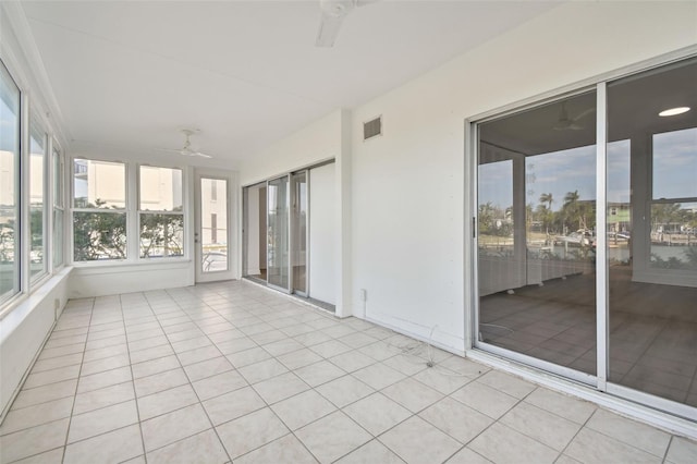 unfurnished sunroom with ceiling fan