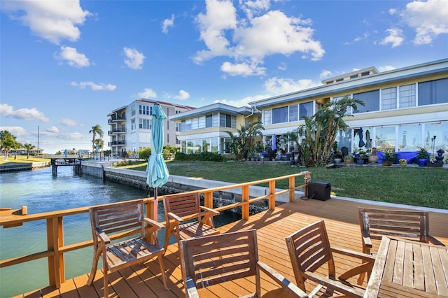 dock area featuring a deck with water view and a yard