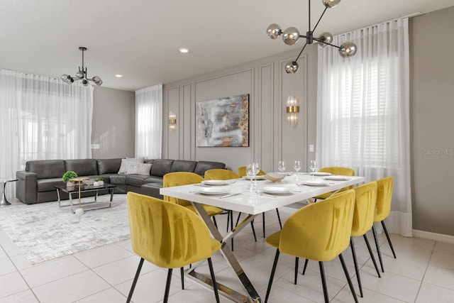 dining area featuring light tile patterned floors and a notable chandelier