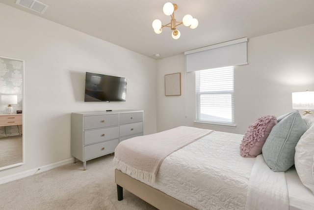 bedroom with light colored carpet and an inviting chandelier