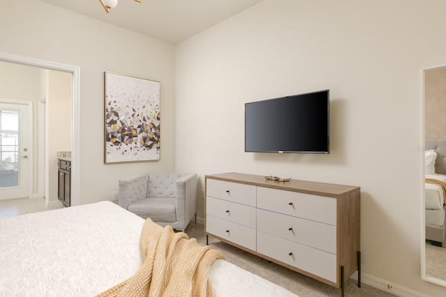 bedroom with light colored carpet and ensuite bath