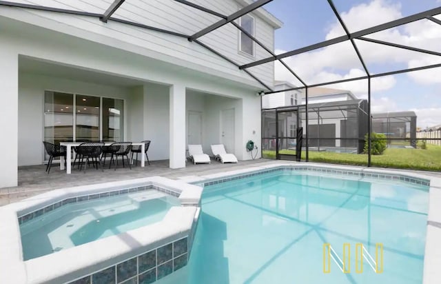 view of pool with glass enclosure, an in ground hot tub, and a patio