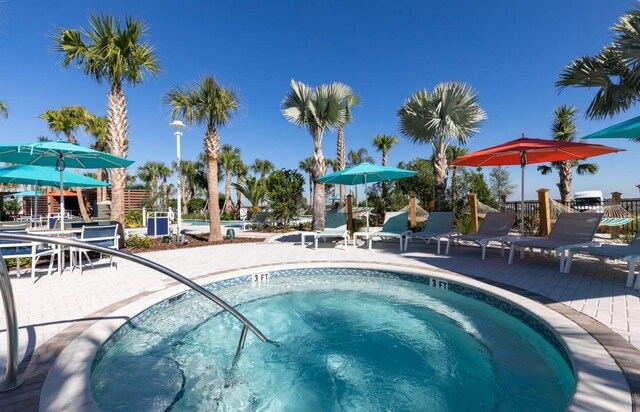 view of swimming pool featuring a patio and a hot tub