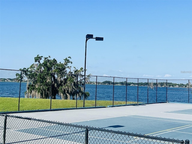 view of tennis court featuring a water view