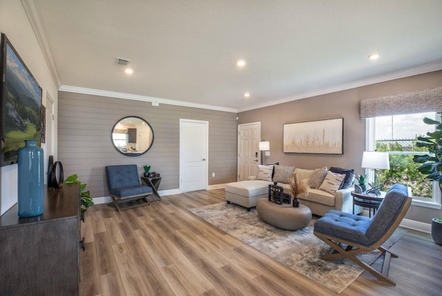 living room with wood-type flooring, ornamental molding, and wood walls