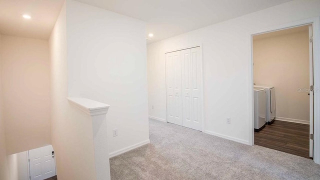 hallway with carpet and washing machine and clothes dryer