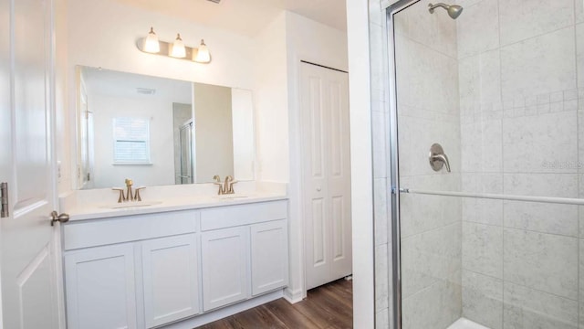 bathroom with hardwood / wood-style floors, vanity, and an enclosed shower