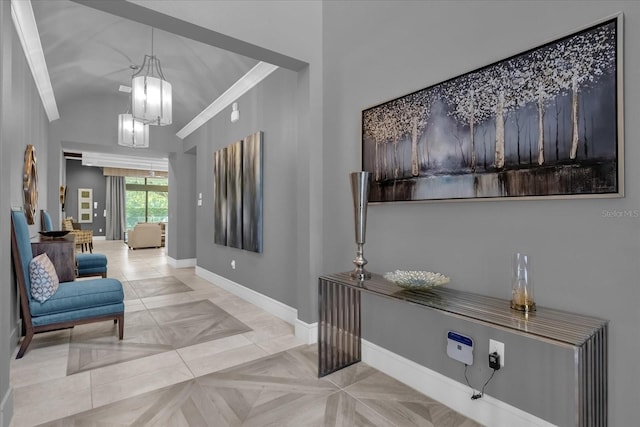 corridor featuring a notable chandelier, lofted ceiling, ornamental molding, and light parquet floors