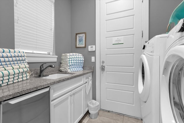 washroom featuring washing machine and dryer, sink, and light tile patterned floors