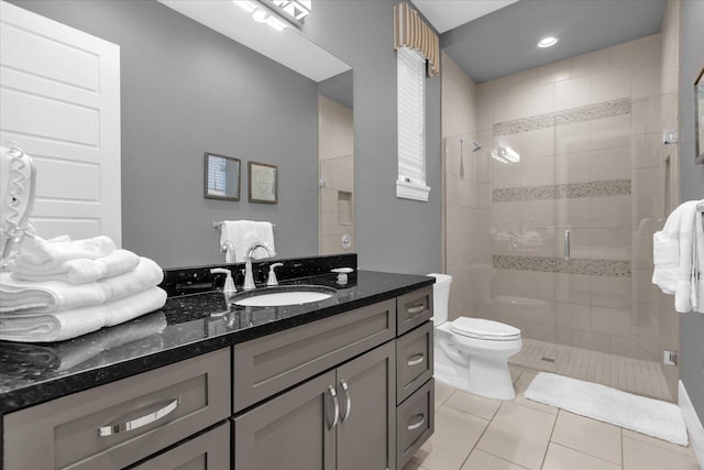 bathroom with tile patterned flooring, vanity, toilet, and walk in shower