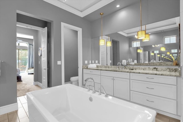 bathroom featuring ornamental molding, vanity, ceiling fan, toilet, and a bathing tub