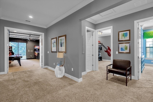 interior space with ceiling fan, light colored carpet, and ornamental molding