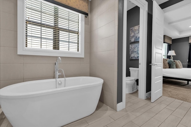 bathroom with toilet, tile walls, and a tub