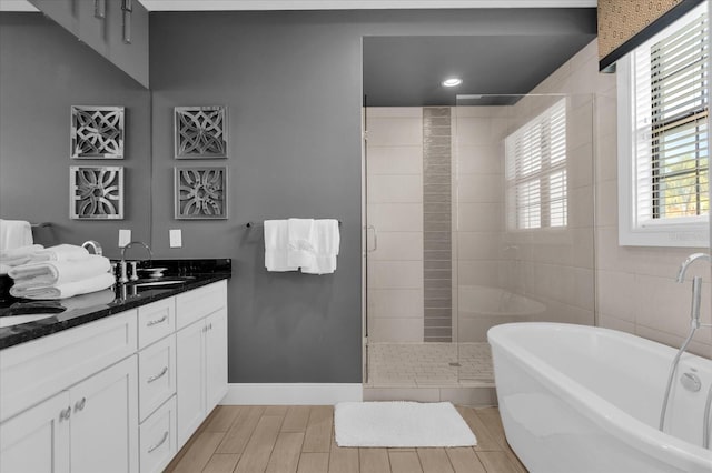 bathroom with hardwood / wood-style flooring, vanity, a healthy amount of sunlight, and separate shower and tub