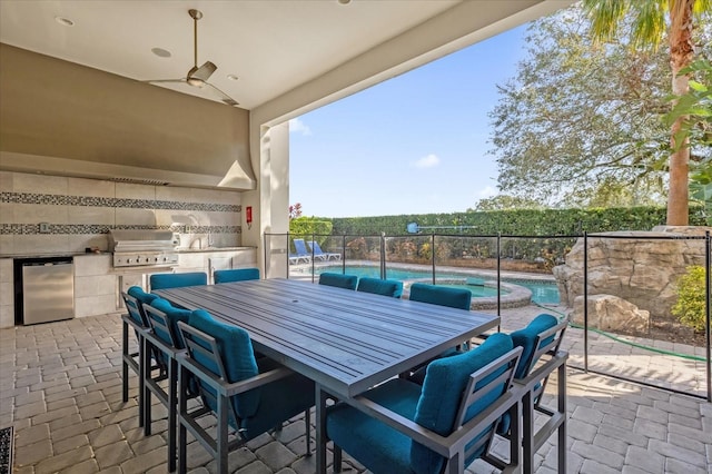 view of patio featuring ceiling fan, a fenced in pool, grilling area, and an outdoor kitchen