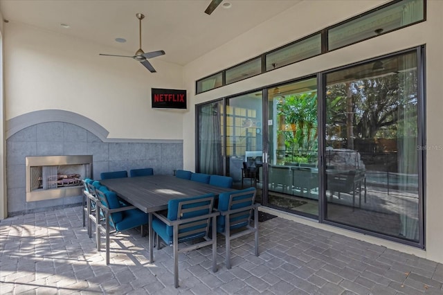 view of patio with ceiling fan and a tiled fireplace