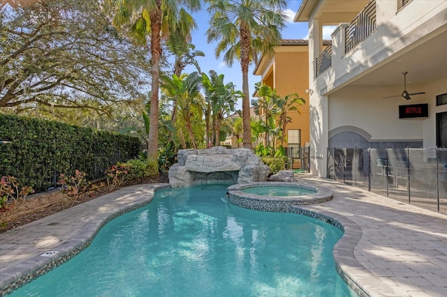 view of pool with ceiling fan and an in ground hot tub