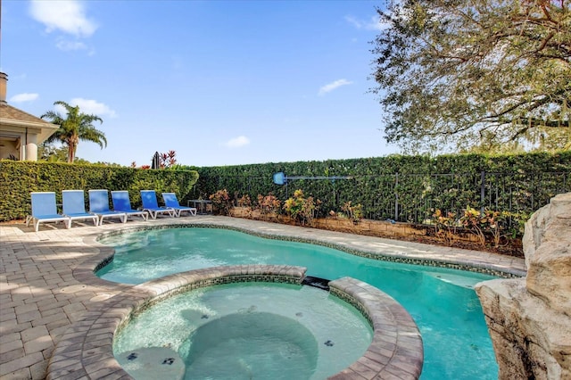 view of swimming pool featuring a patio area and an in ground hot tub