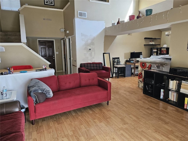 living room with hardwood / wood-style floors and a towering ceiling