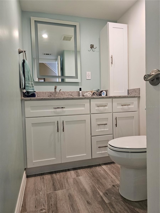 bathroom featuring hardwood / wood-style floors, vanity, and toilet