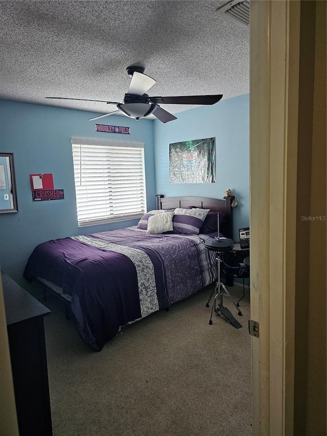 bedroom with carpet, ceiling fan, and a textured ceiling