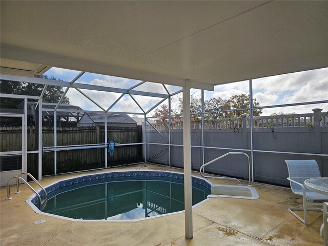 view of swimming pool with a patio and glass enclosure