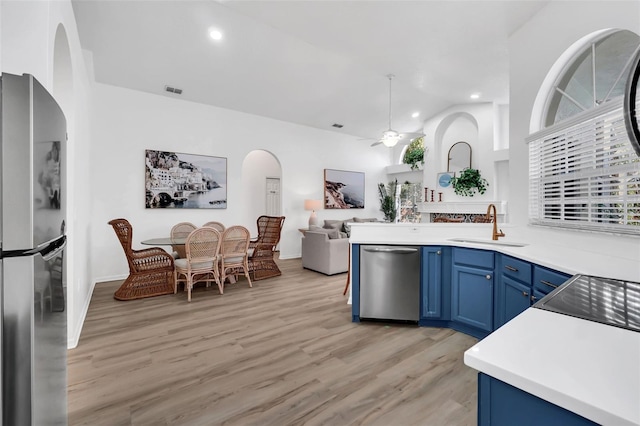 kitchen featuring ceiling fan, sink, blue cabinets, appliances with stainless steel finishes, and light wood-type flooring